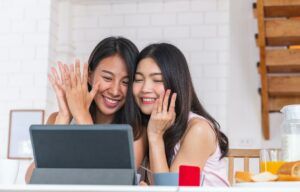 asian couple lesbian getting marriage and showing ring to friend infront of table