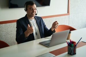 Cheerful online business worker having discussion through laptop